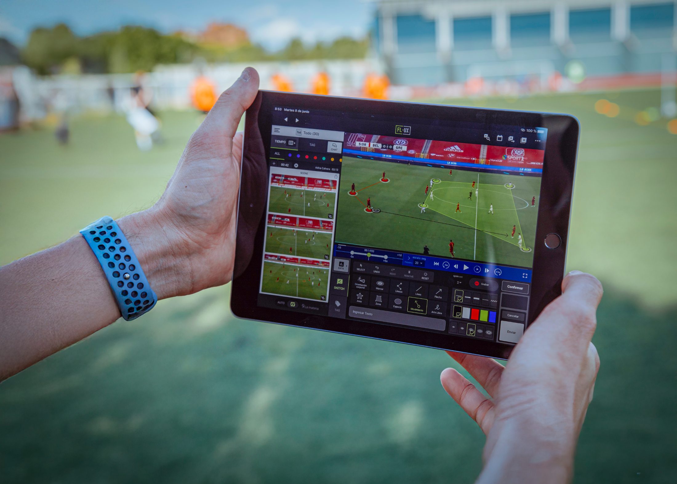 A coach reviewing set-piece analysis on a tablet pitchside