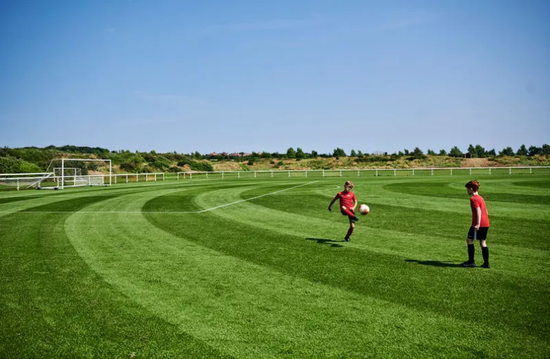 Young players training on a full-size grass pitch