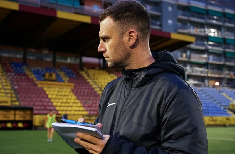 An analyst taking notes pitchside